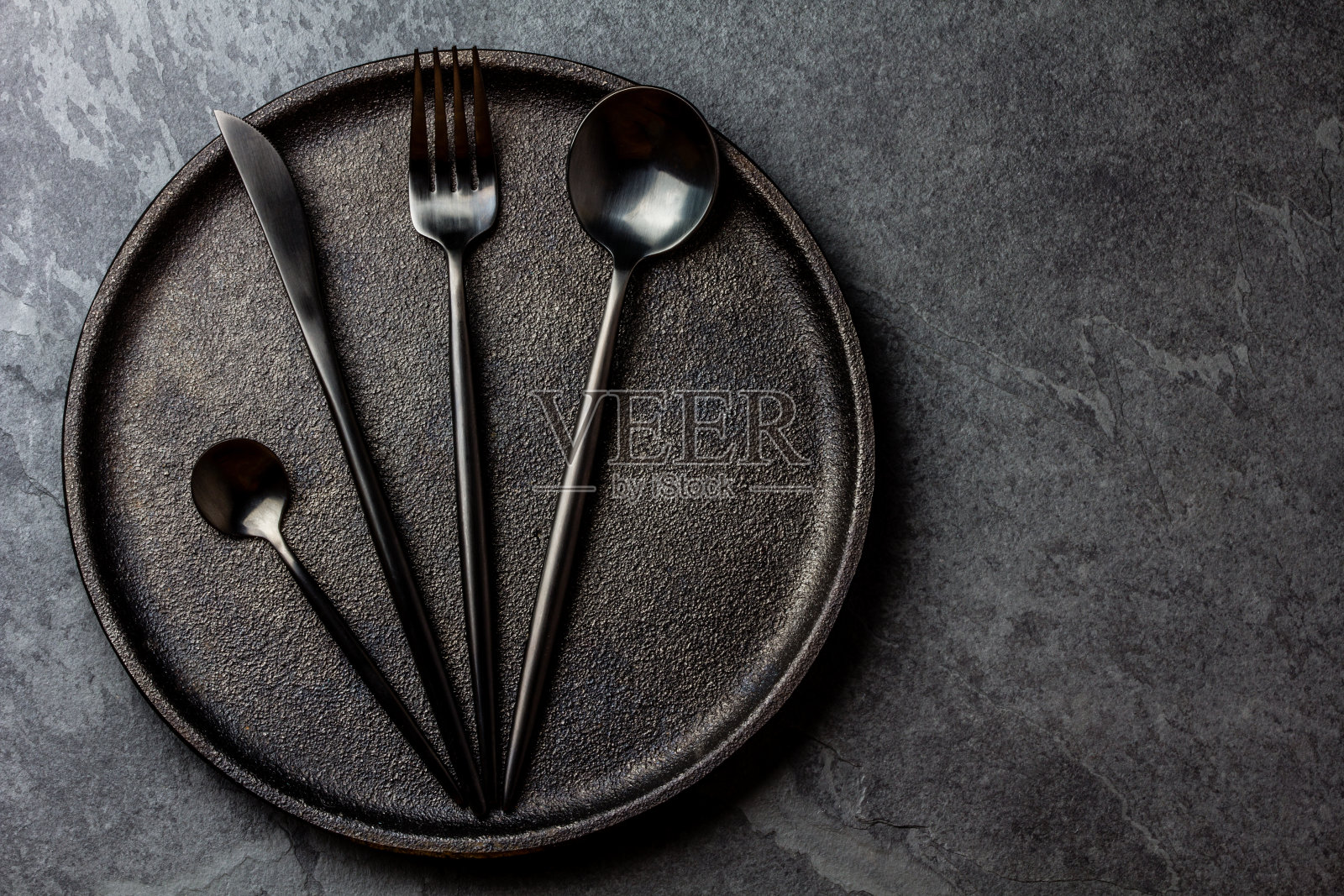 餐具放在盘子上。黑色表设置。俯视图照片摄影图片