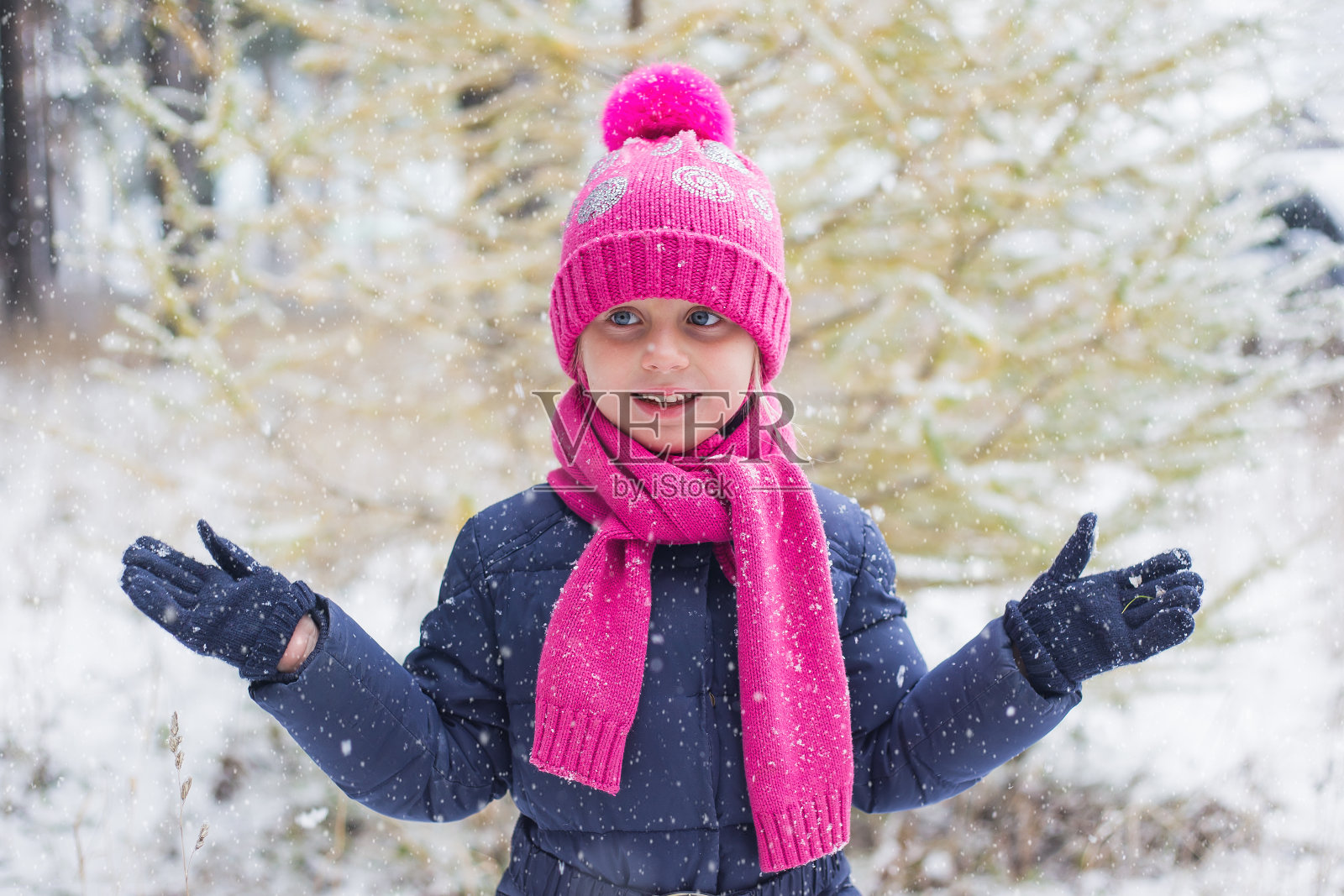 下雪。女孩走在白雪覆盖的森林里。她抓住了照片摄影图片