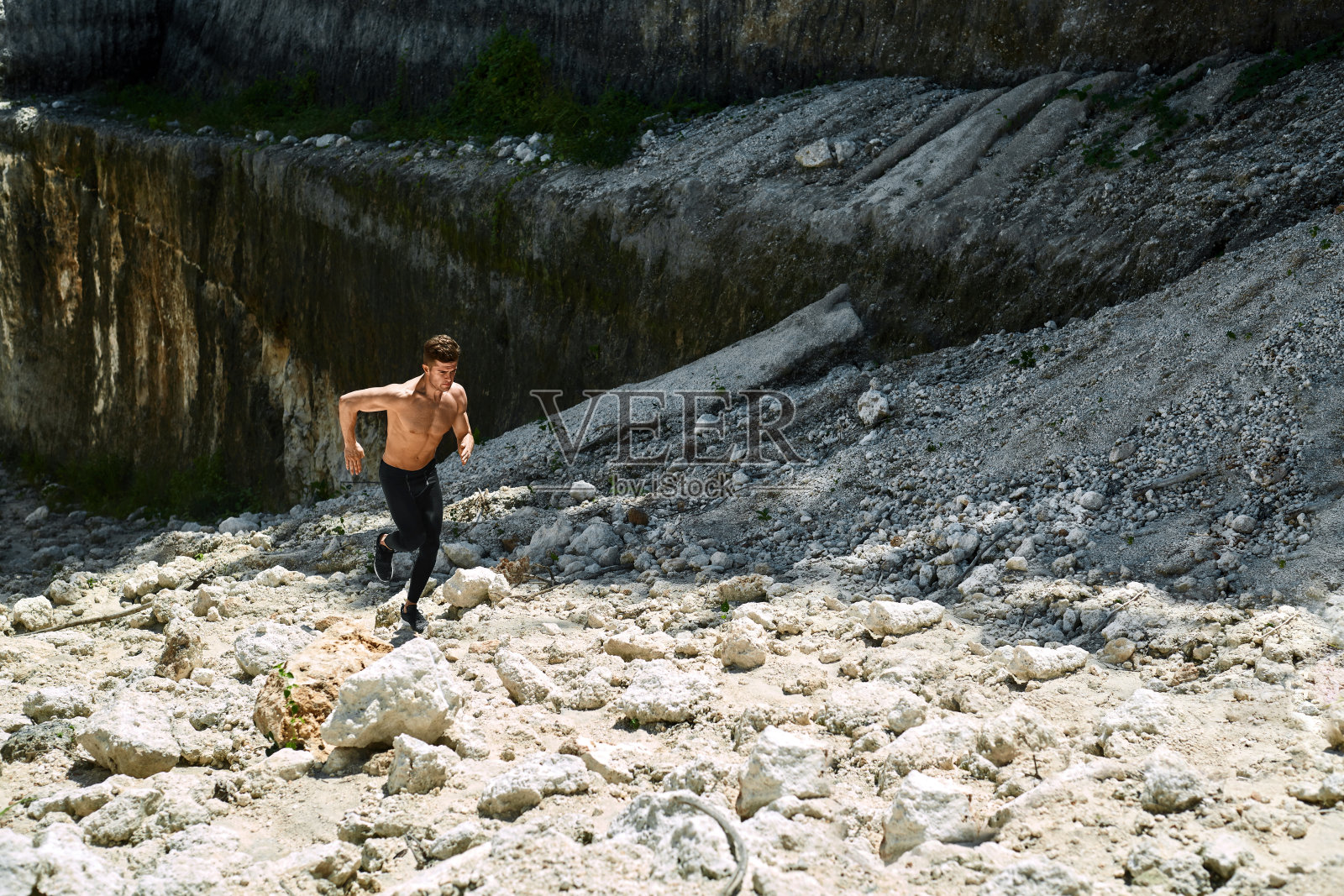 男人跑上岩石山，在户外锻炼。Sp照片摄影图片