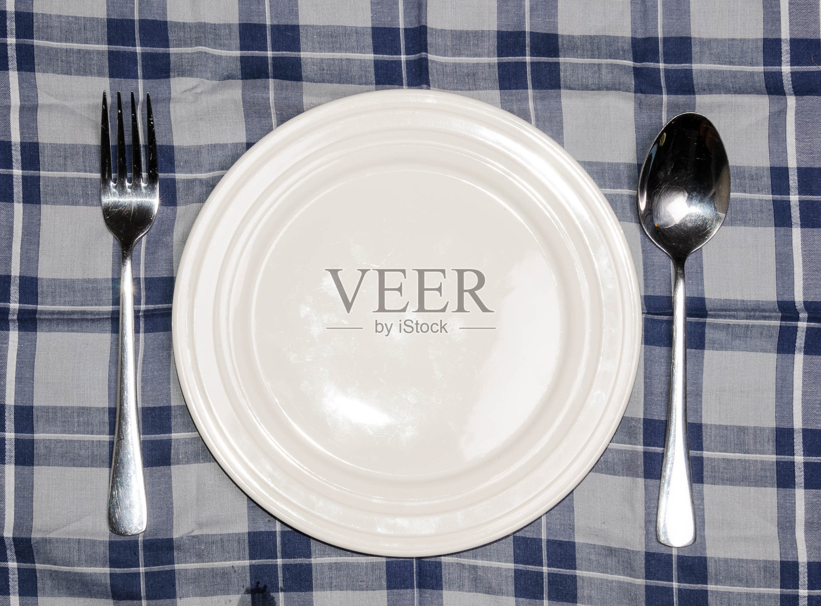 在桌布的背景上放一个带有刀叉的空白盘子照片摄影图片