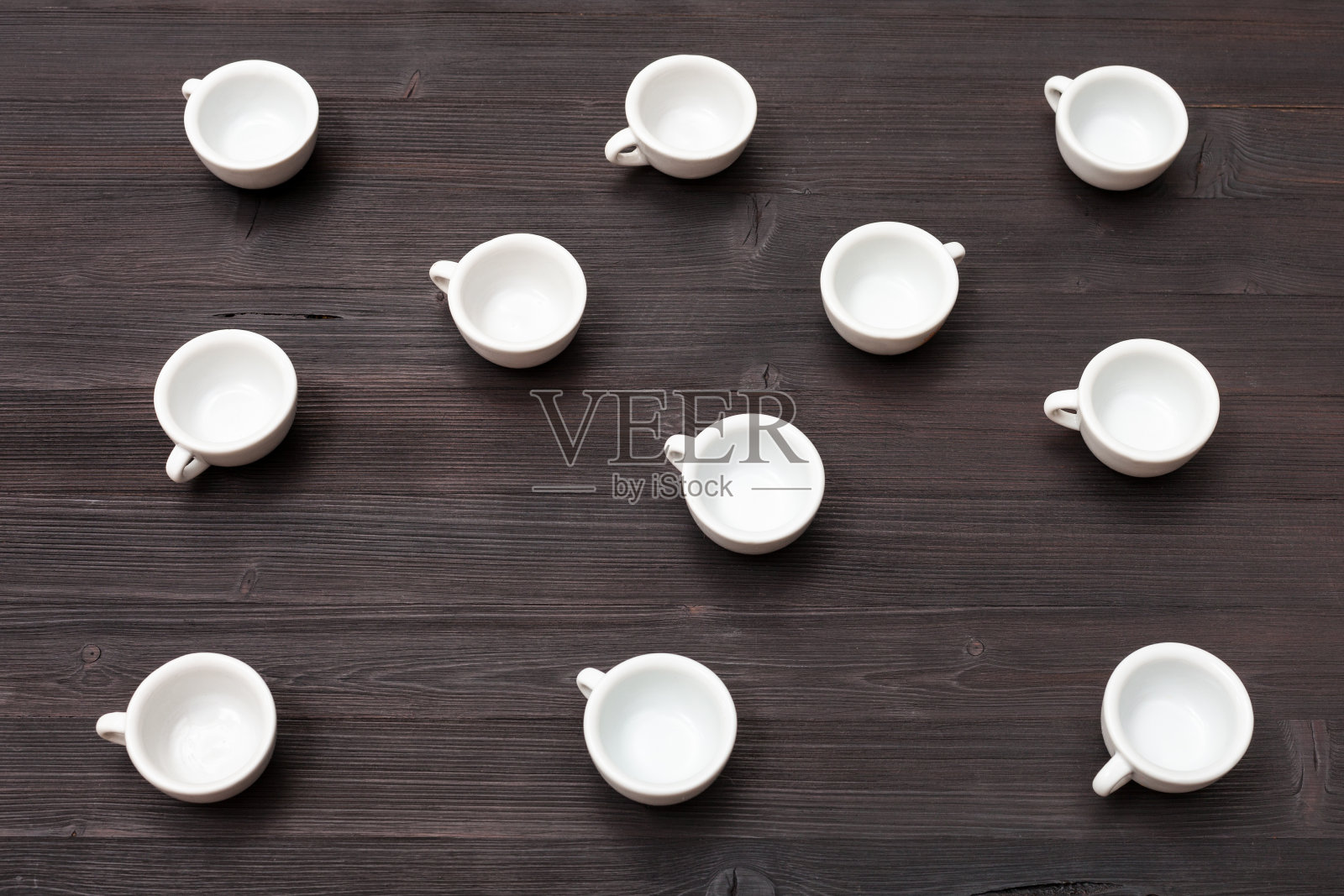 上面的观点，许多白色的杯子在深棕色的桌子照片摄影图片