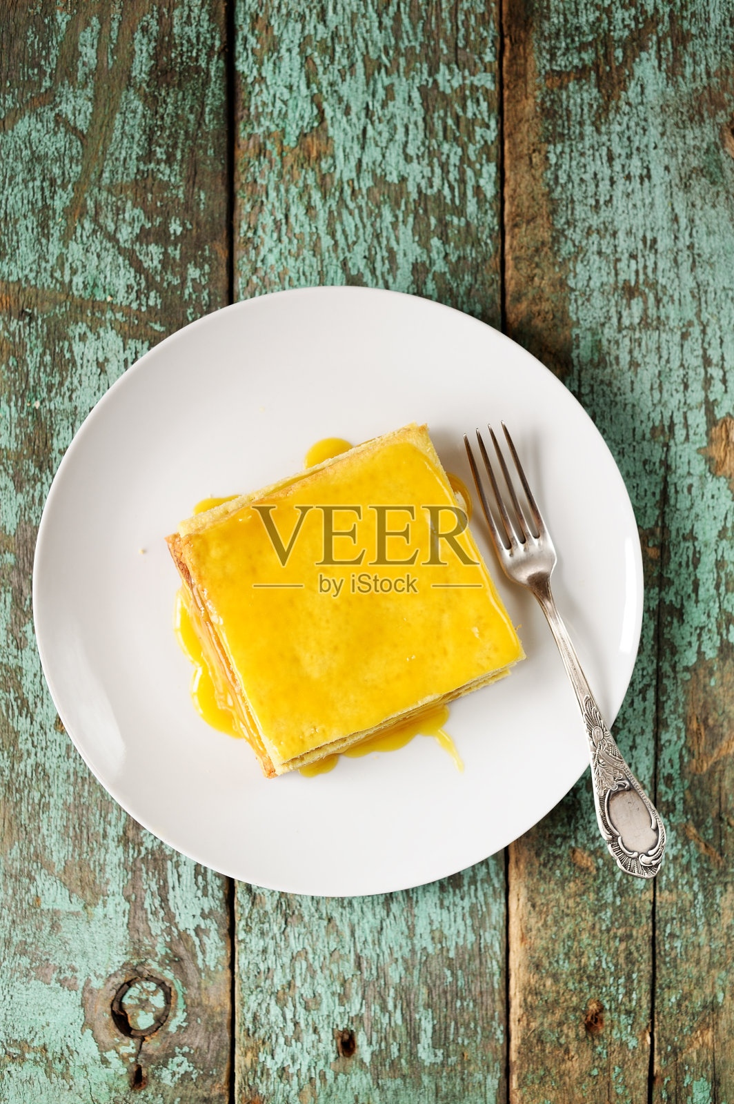 方形柠檬蛋糕放在破旧的绿松石板上照片摄影图片