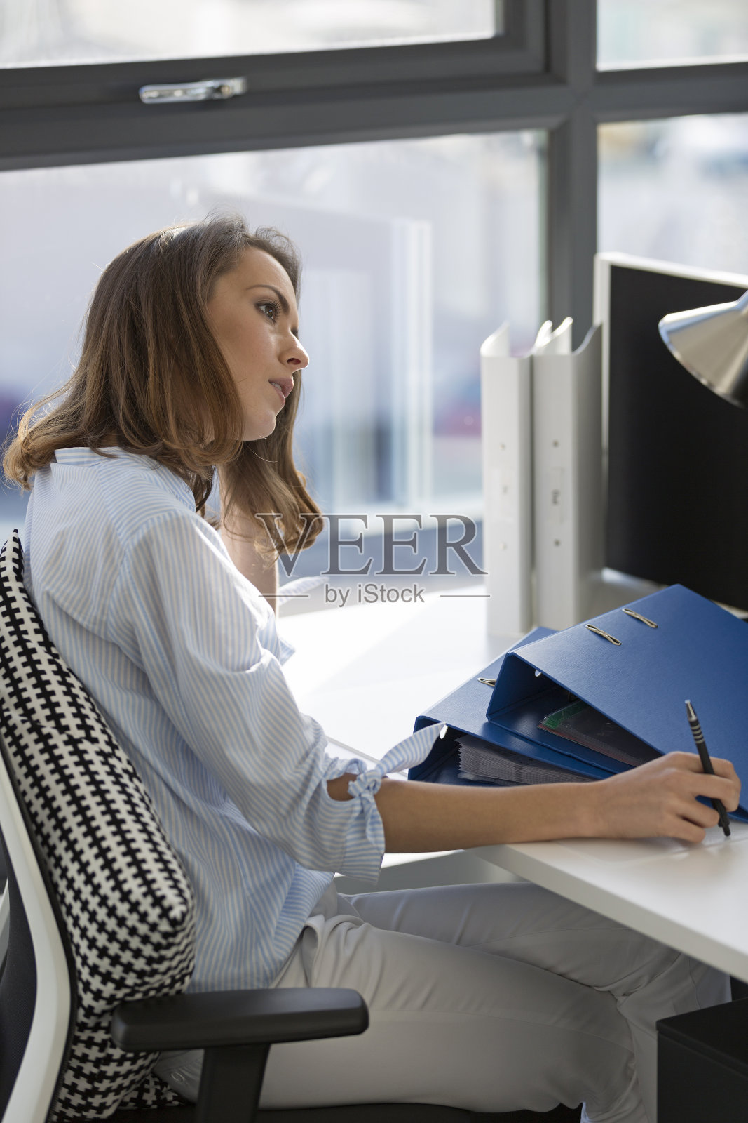 坐在办公桌前的女人照片摄影图片