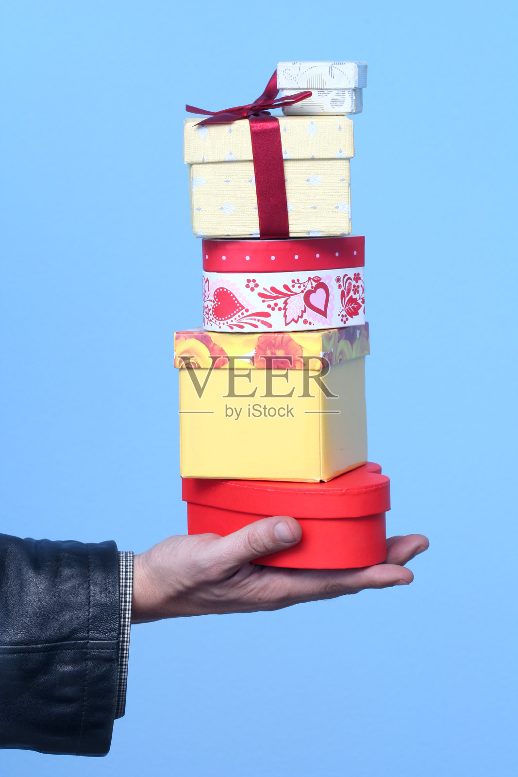 蓝色背景下手持礼品盒的裁剪图像照片摄影图片