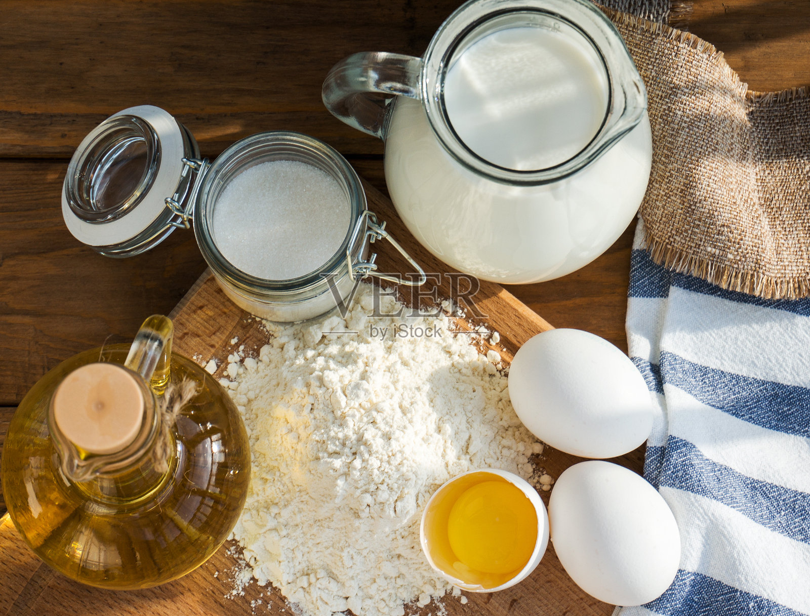 煎饼原料。牛奶、鸡蛋、面粉、油、糖。木制背景照片摄影图片