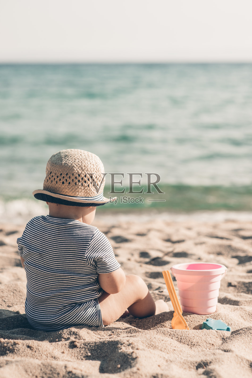 可爱的小男孩在热带海滩上玩海滩玩具照片摄影图片