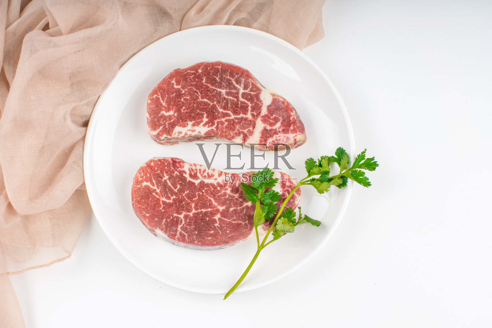 生牛排放在盘子里照片摄影图片