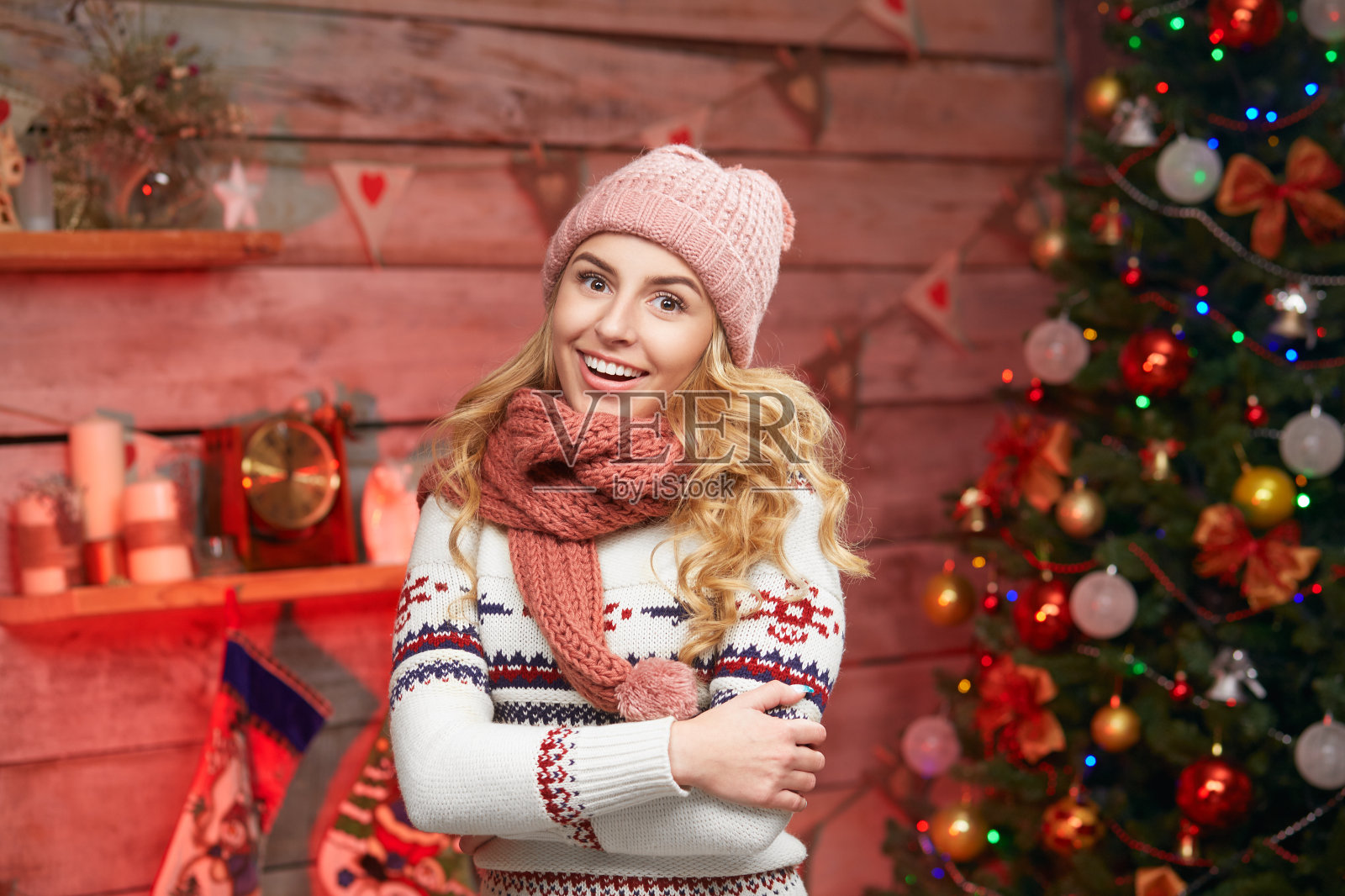 微笑的年轻女子在帽子和围巾的圣诞树照片摄影图片