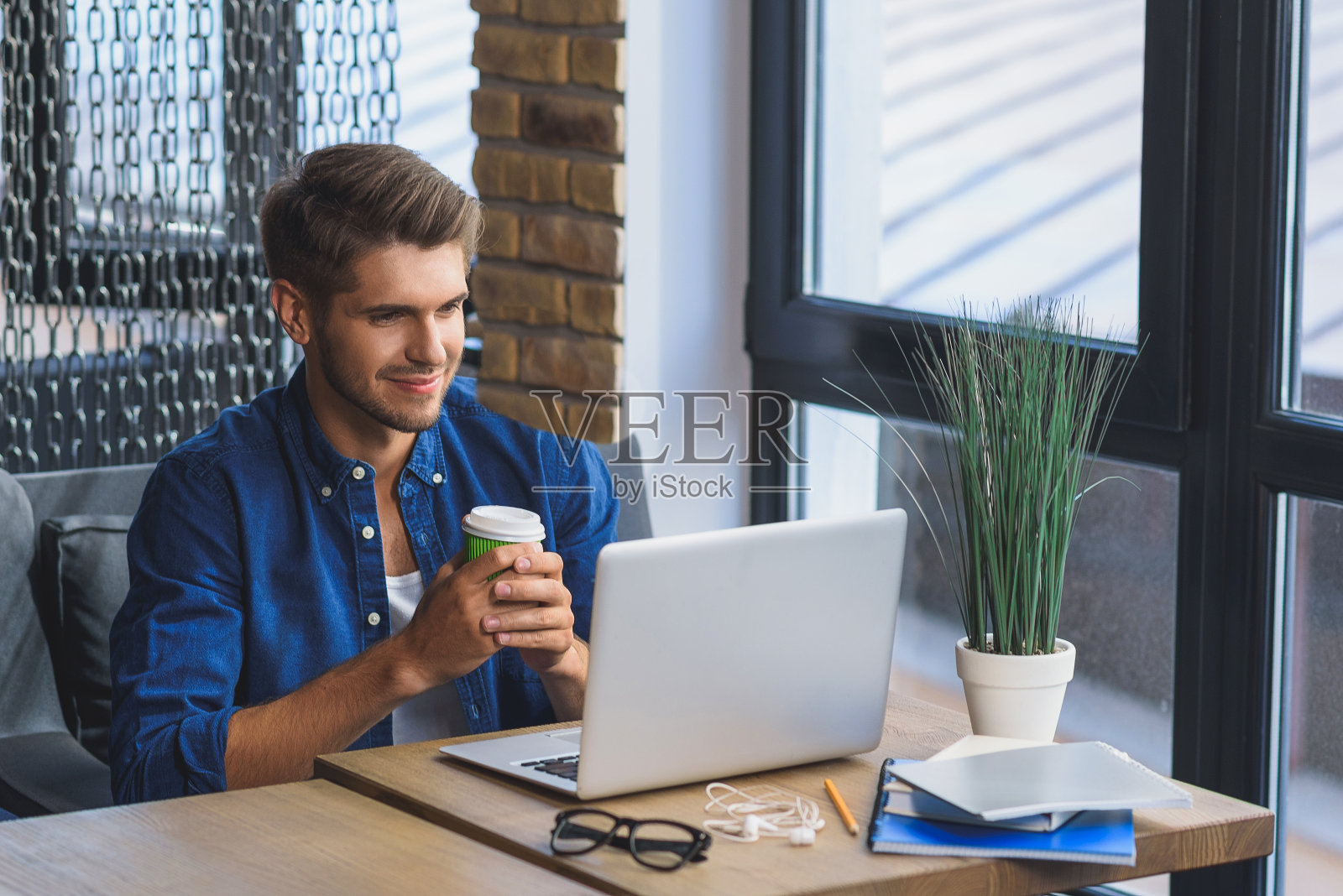 自豪的自由职业者微笑着对着他的笔记本电脑照片摄影图片