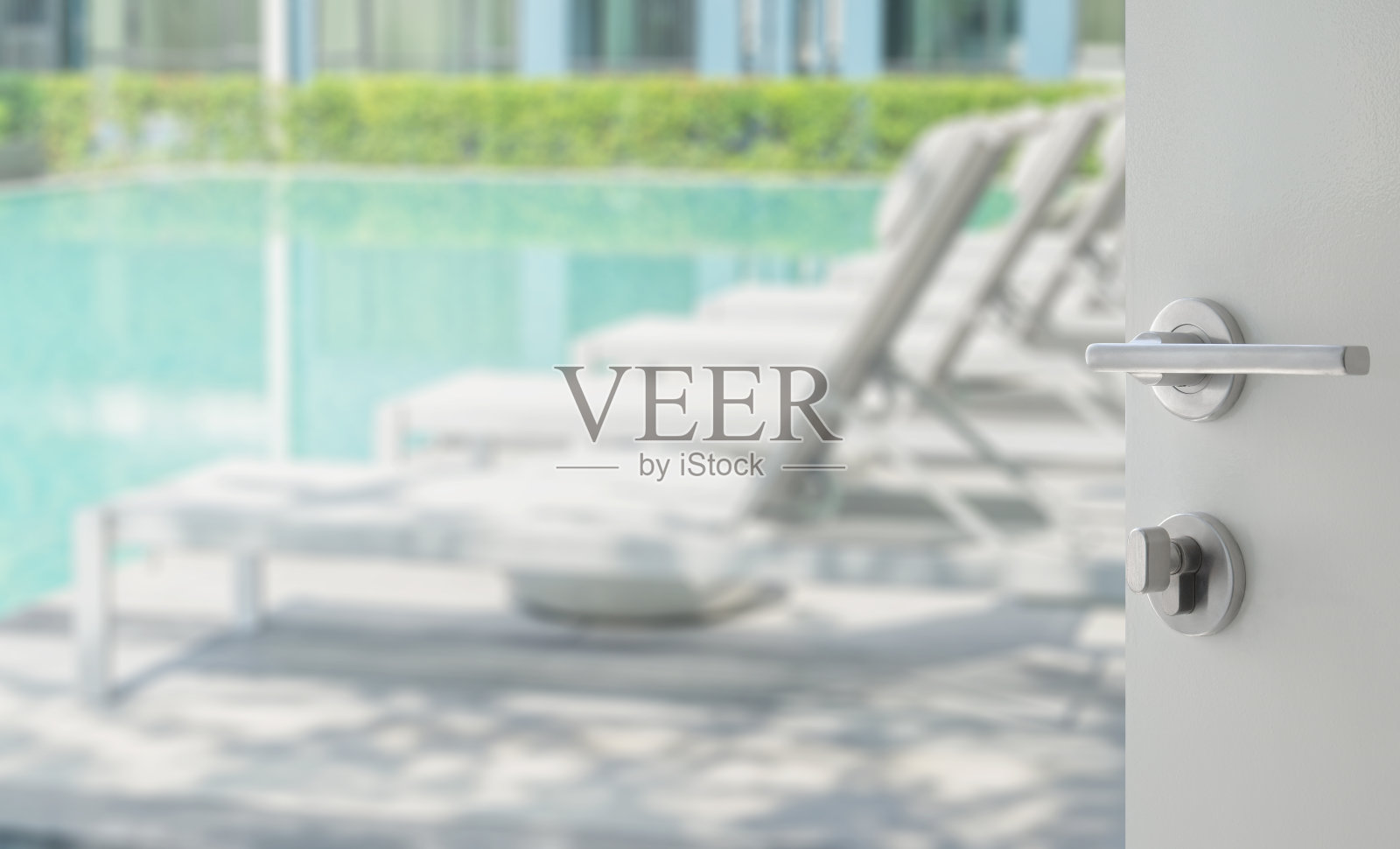 打开白色的门到游泳池和沙滩椅照片摄影图片