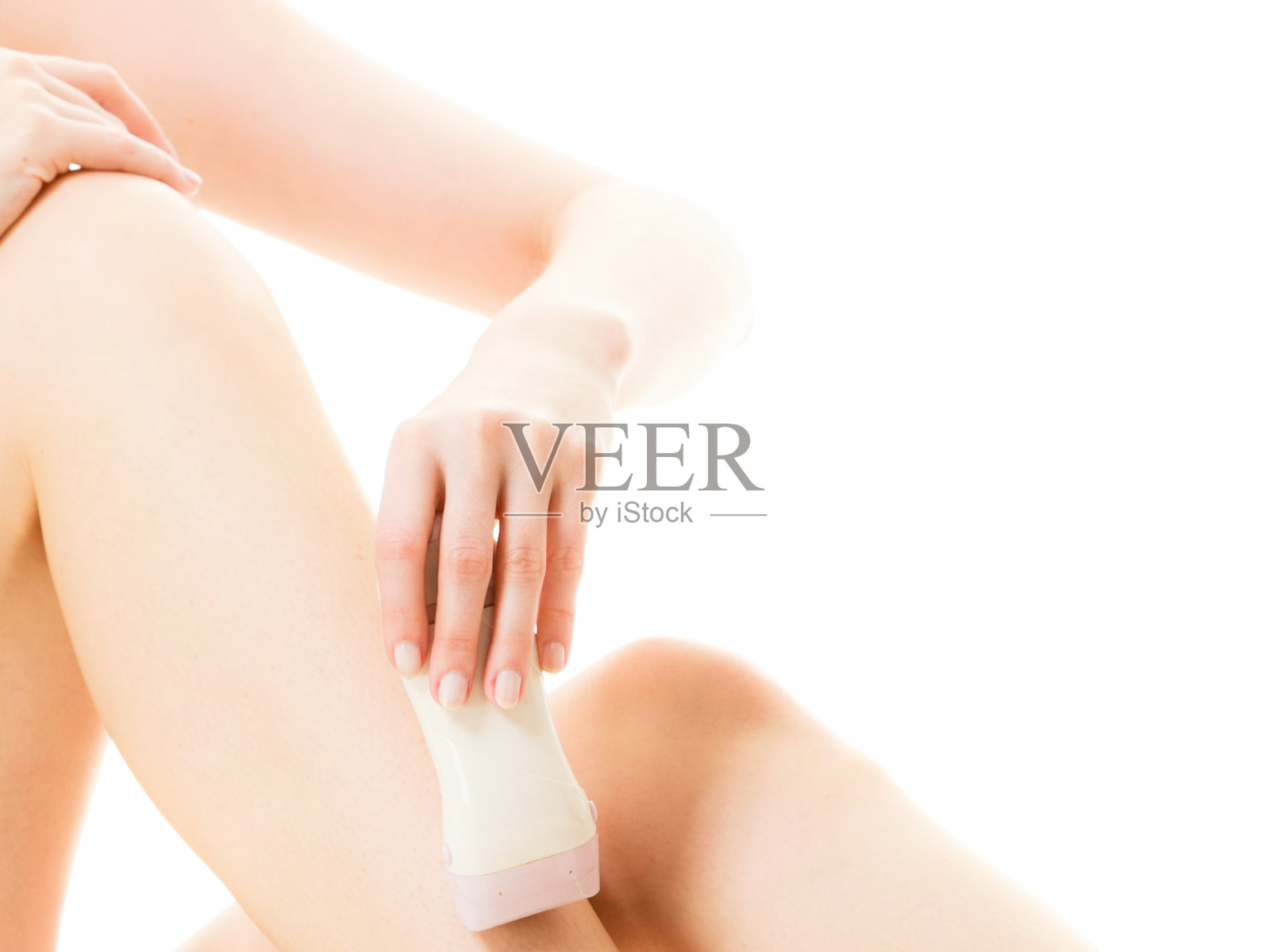 女人用电动剃须刀刮腿毛照片摄影图片