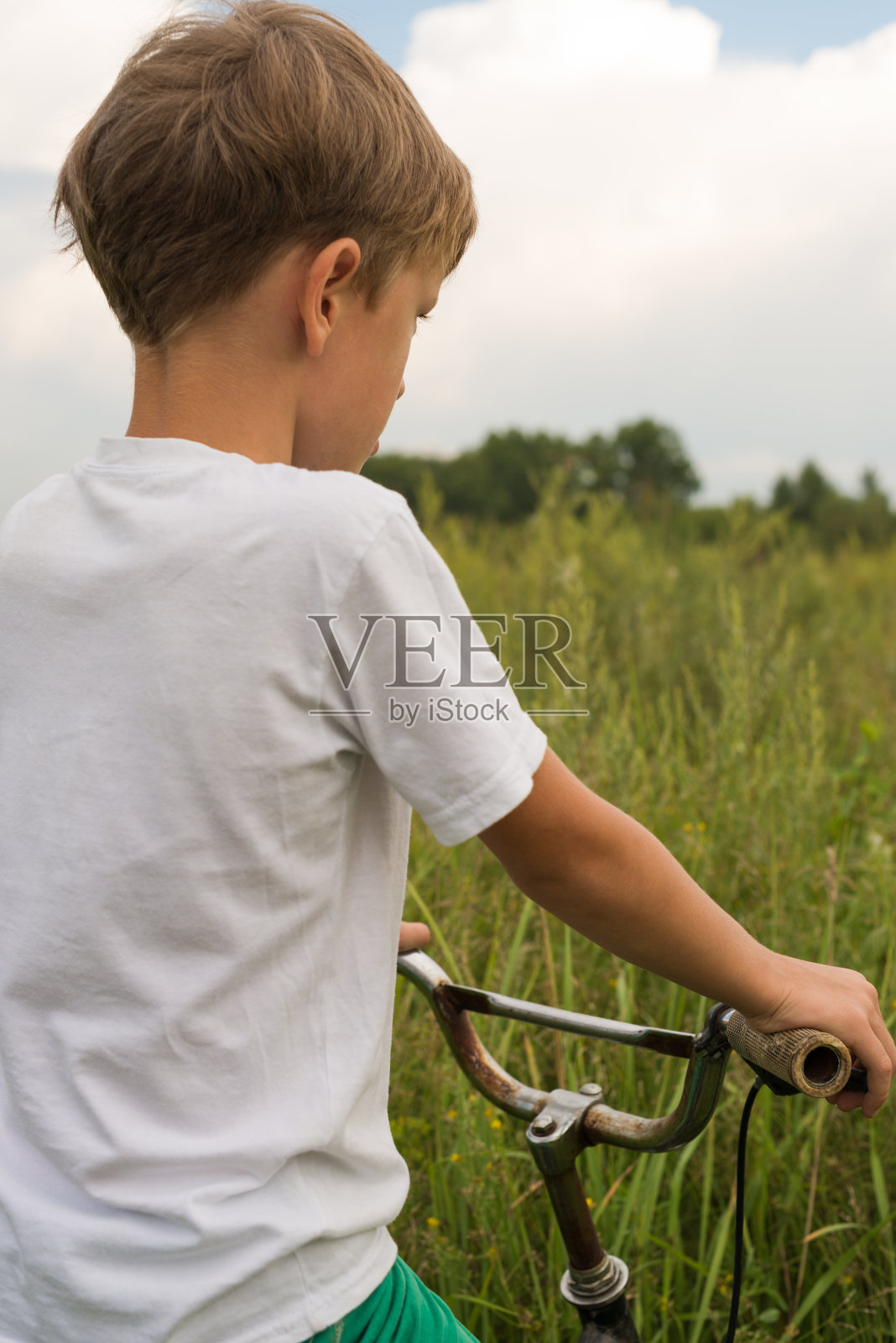男孩在一个阳光明媚的日子里在户外骑自行车照片摄影图片