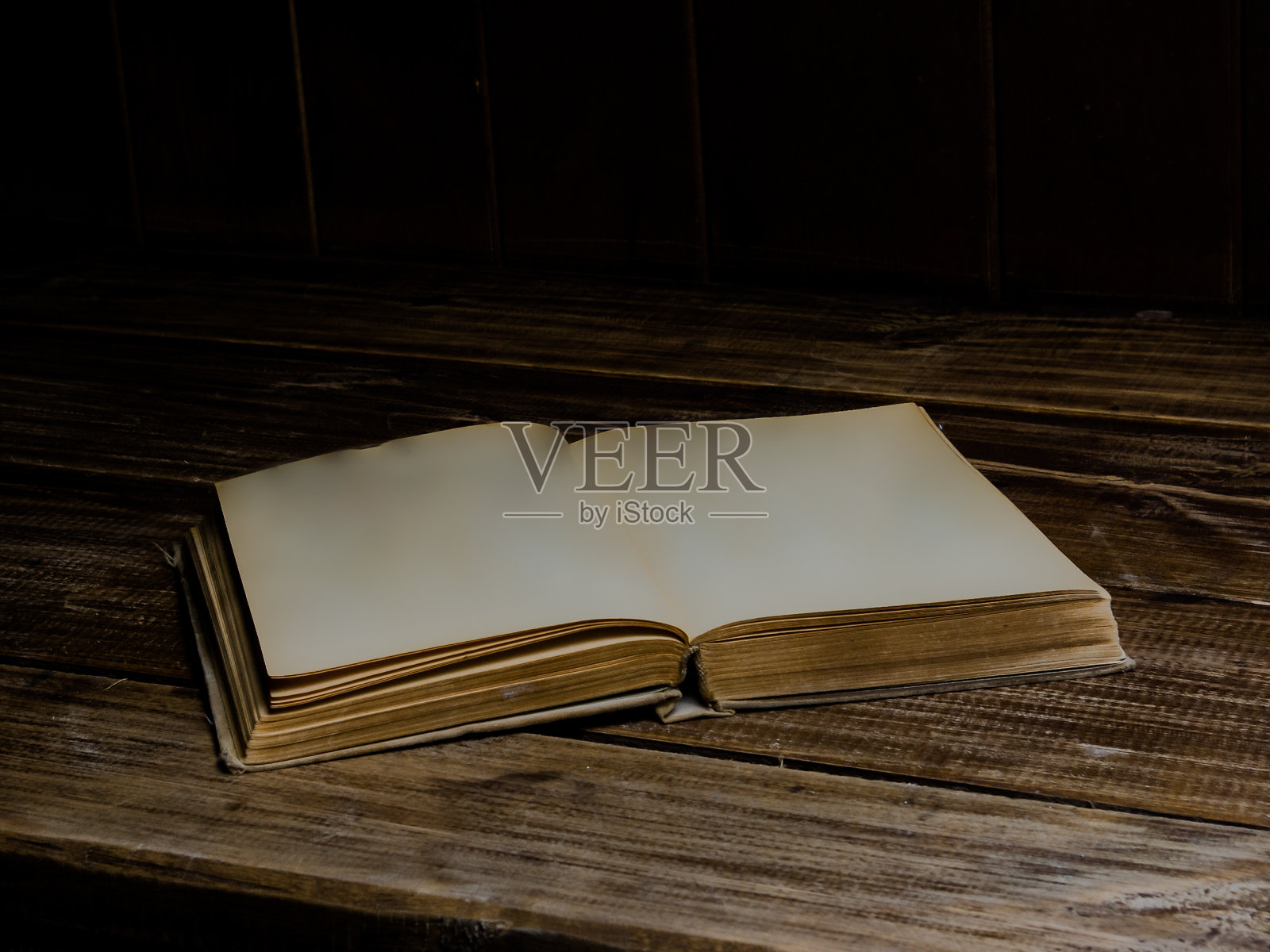 一本打开的古书放在木桌上。空白页照片摄影图片