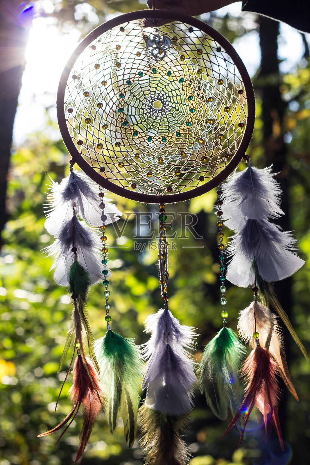 用羽毛、皮革、珠子和绳子做成的捕梦网照片摄影图片