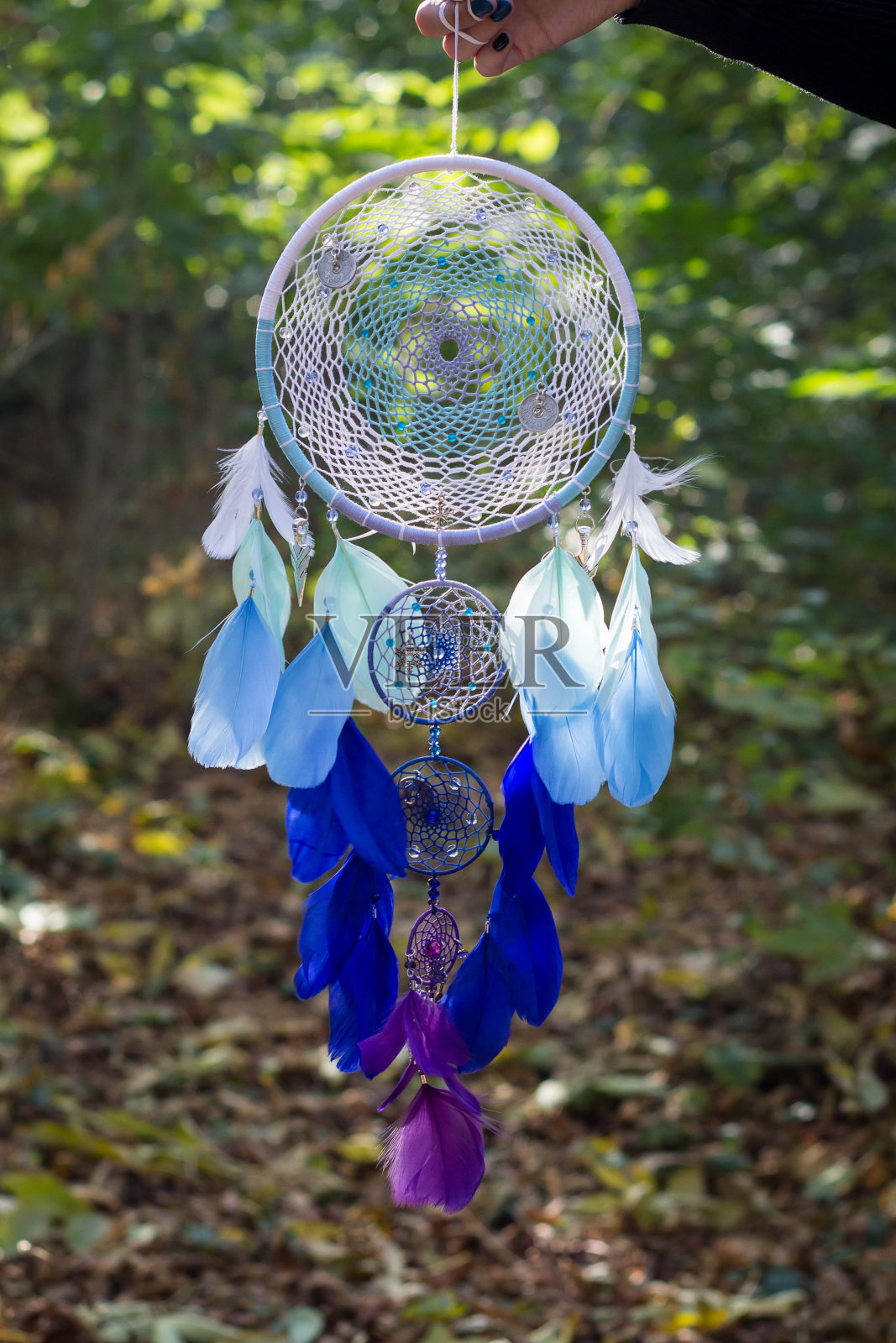 用羽毛、皮革、珠子和绳子做成的捕梦网照片摄影图片