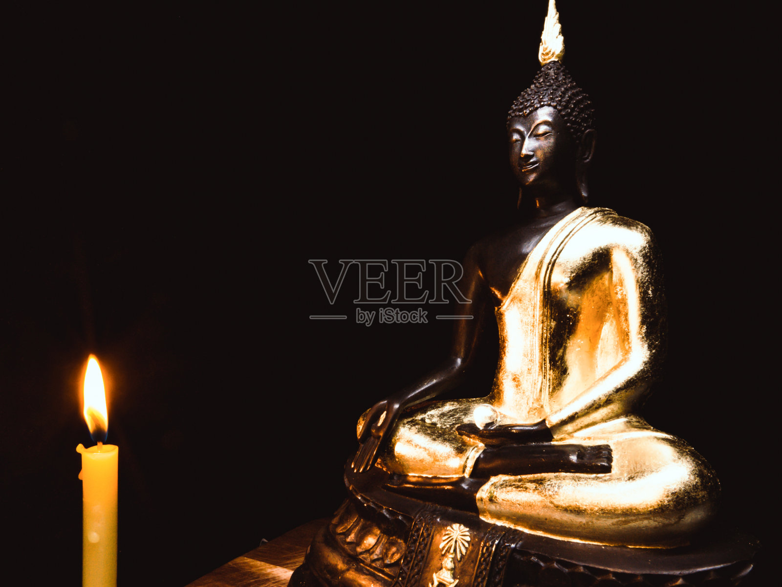 佛像和灯光蜡烛与光暗背景。照片摄影图片