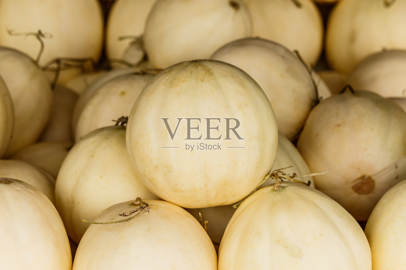 堆在桌子上出售的哈密瓜照片摄影图片