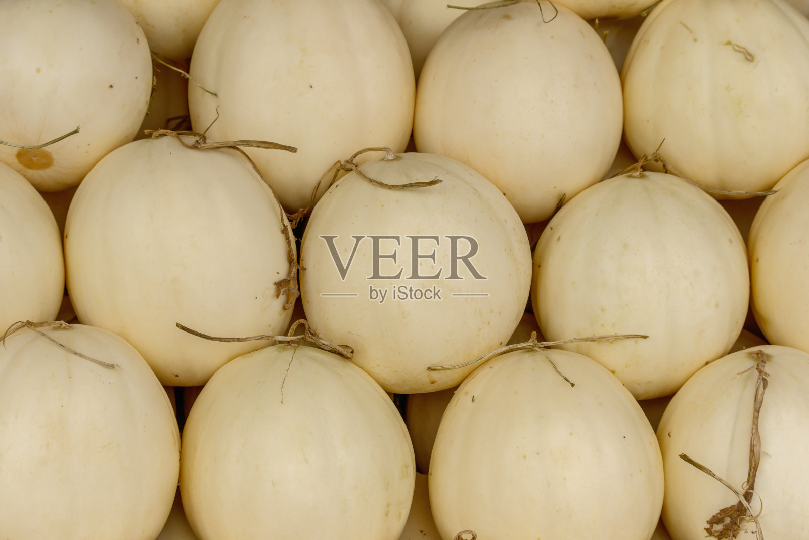 堆在桌子上出售的哈密瓜照片摄影图片