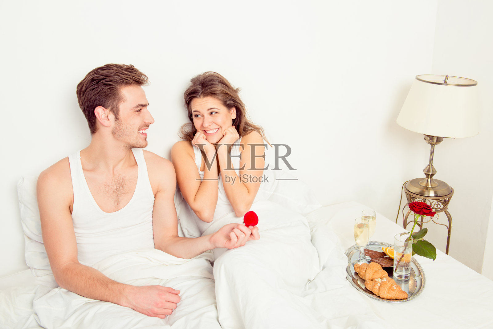 年轻英俊的男人在床上向你求婚照片摄影图片