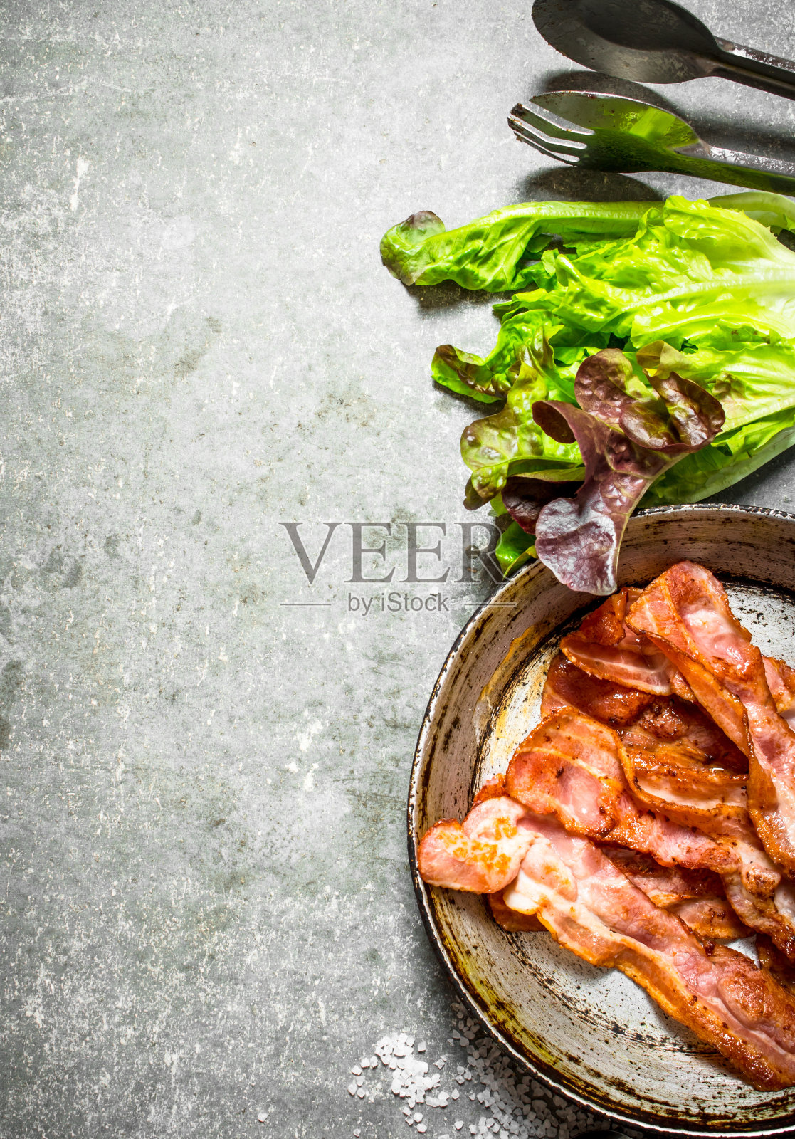 煎锅里的培根，加盐和香草。照片摄影图片