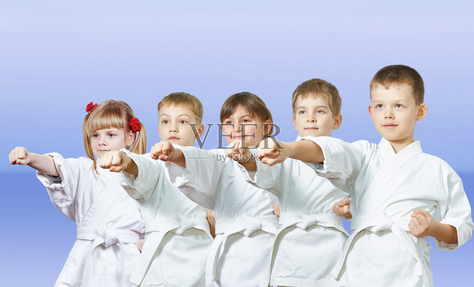 在灯光背景下，小运动员们挥舞着拳头照片摄影图片