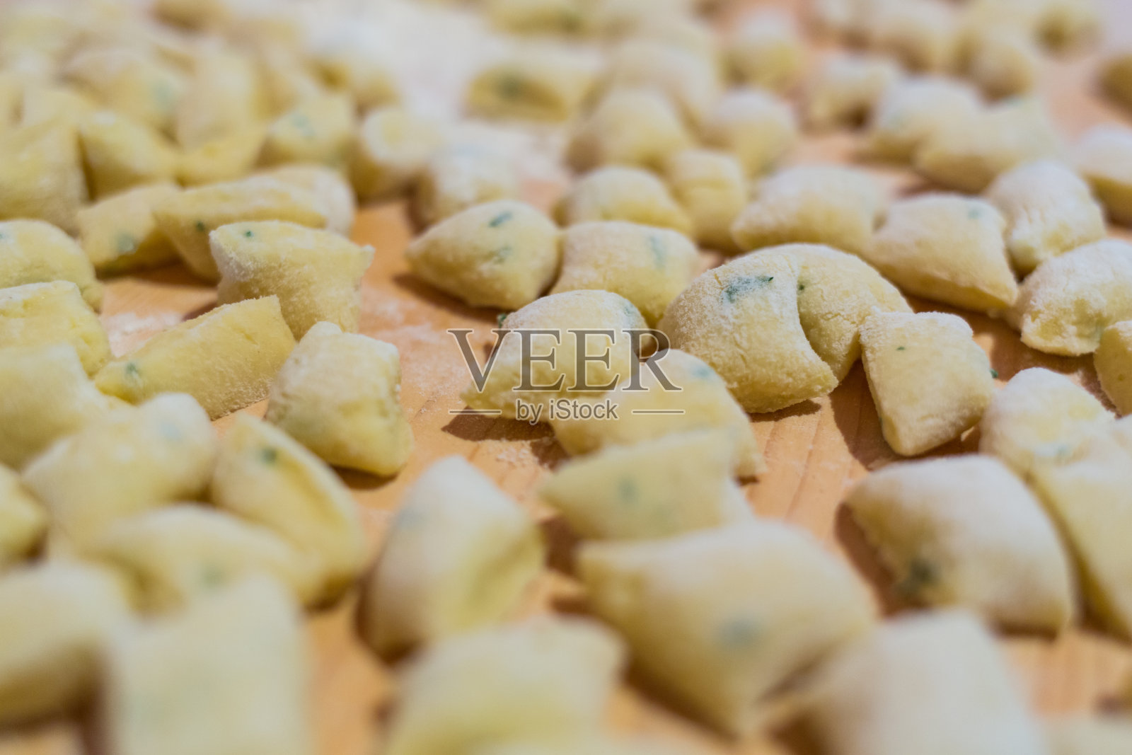 切菜板上的生的自制汤圆，自制的意大利面照片摄影图片