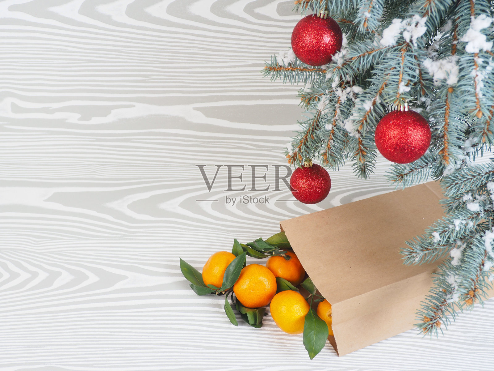 橘子靠近冬天的树。圣诞节的气氛照片摄影图片