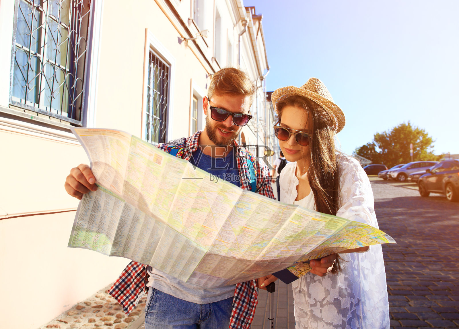 一对快乐的情侣在户外观光，手里拿着地图照片摄影图片