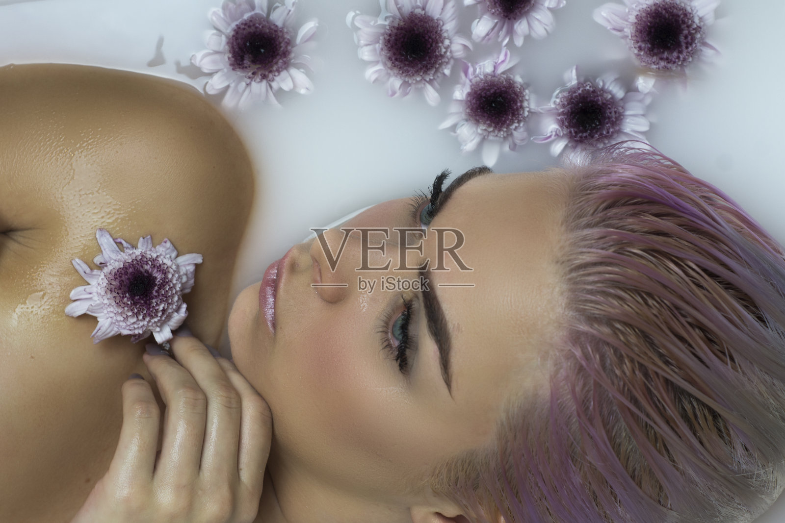 美丽迷人的女士放松在温泉浴与牛奶照片摄影图片