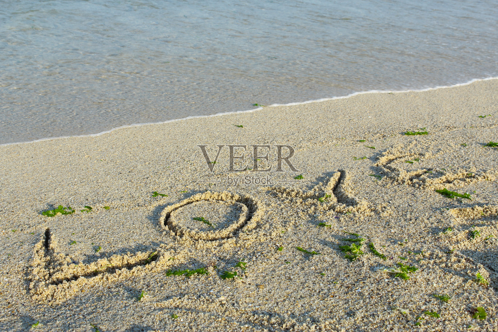 沙滩上的沙滩波涛，画着阳光，爱和心照片摄影图片