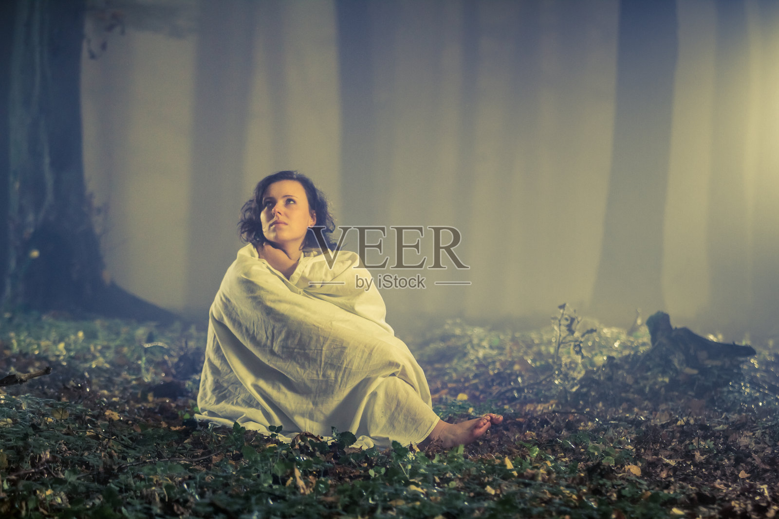 迷雾中黑暗的老森林里的女人照片摄影图片