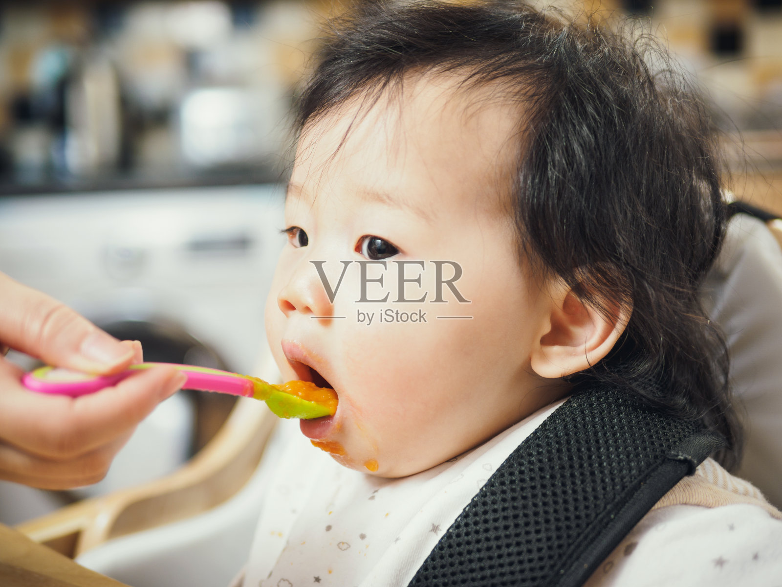 婴儿第一次在高椅上断奶照片摄影图片