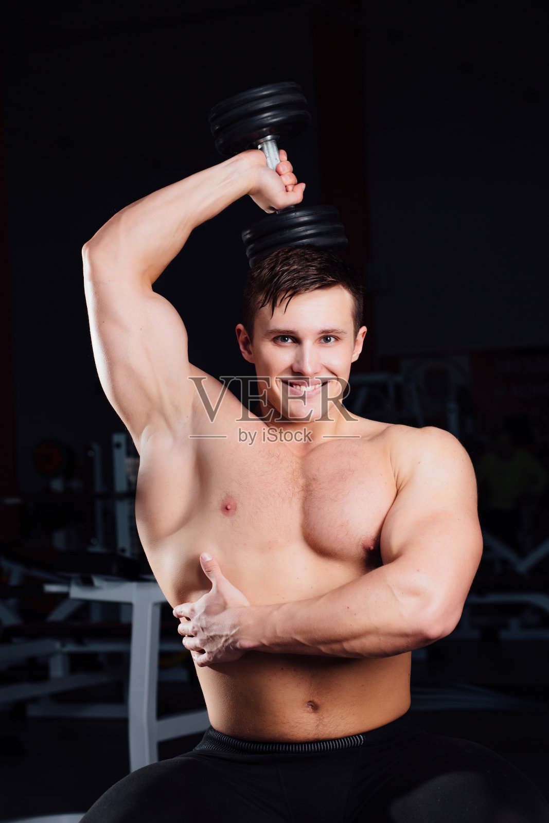 专业健美运动员坐在长凳上练杠铃照片摄影图片