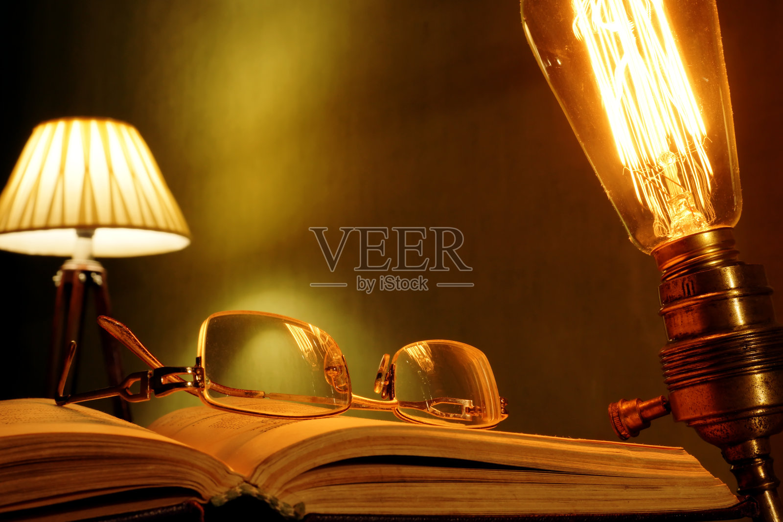 旧书、眼镜和古董灯。照片摄影图片