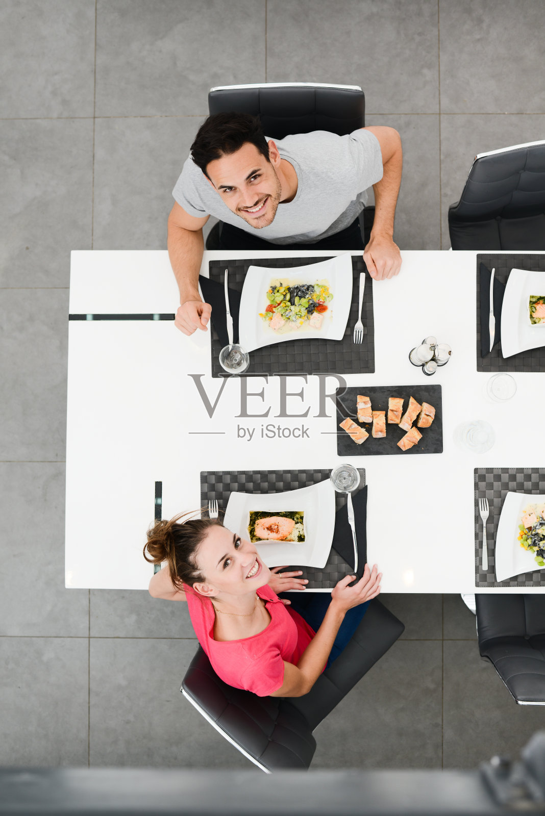 上图是一对兴高采烈的年轻夫妇在现代餐厅吃午餐照片摄影图片