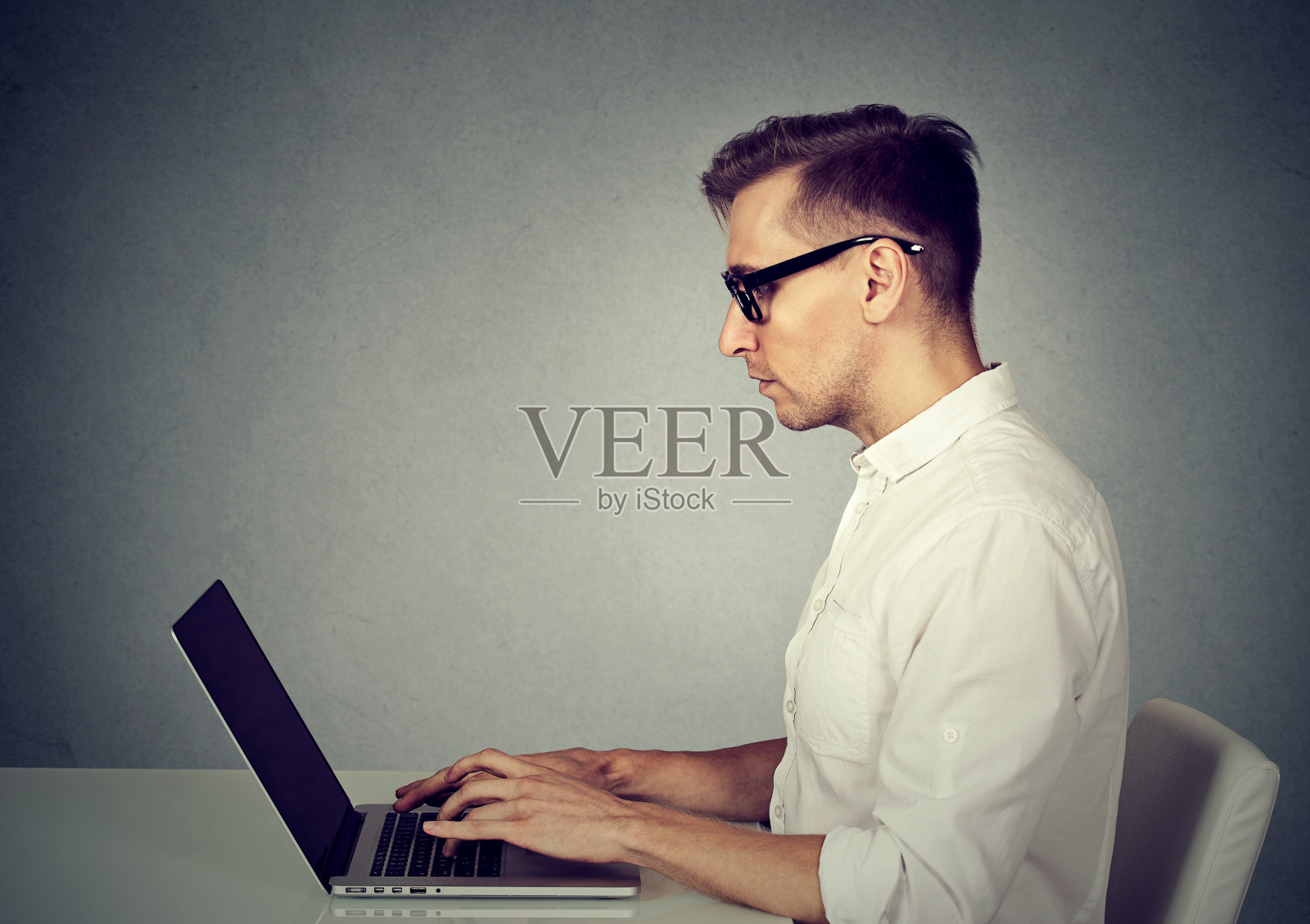 侧面的年轻人使用笔记本电脑照片摄影图片