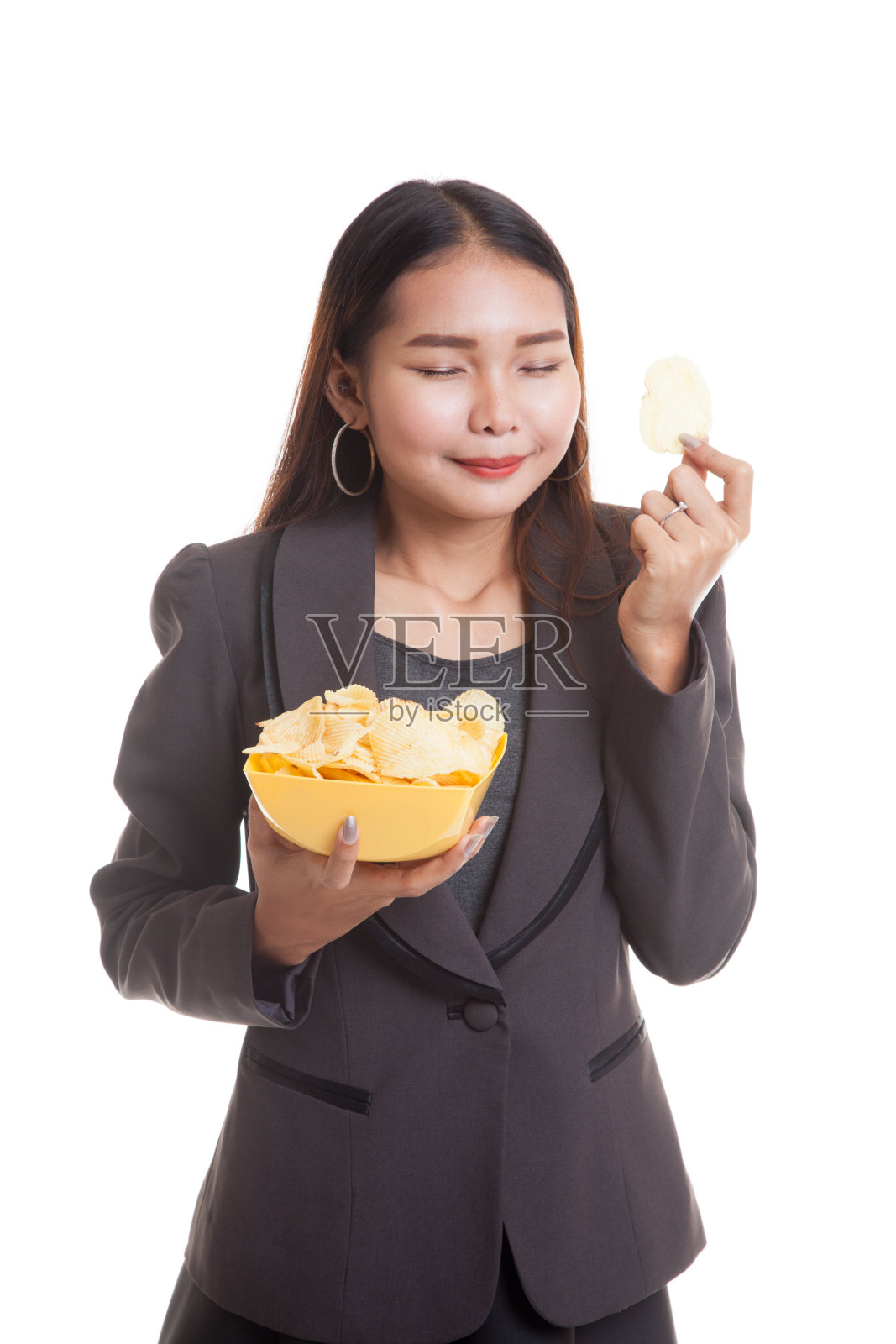 年轻的亚洲妇女吃薯片。照片摄影图片