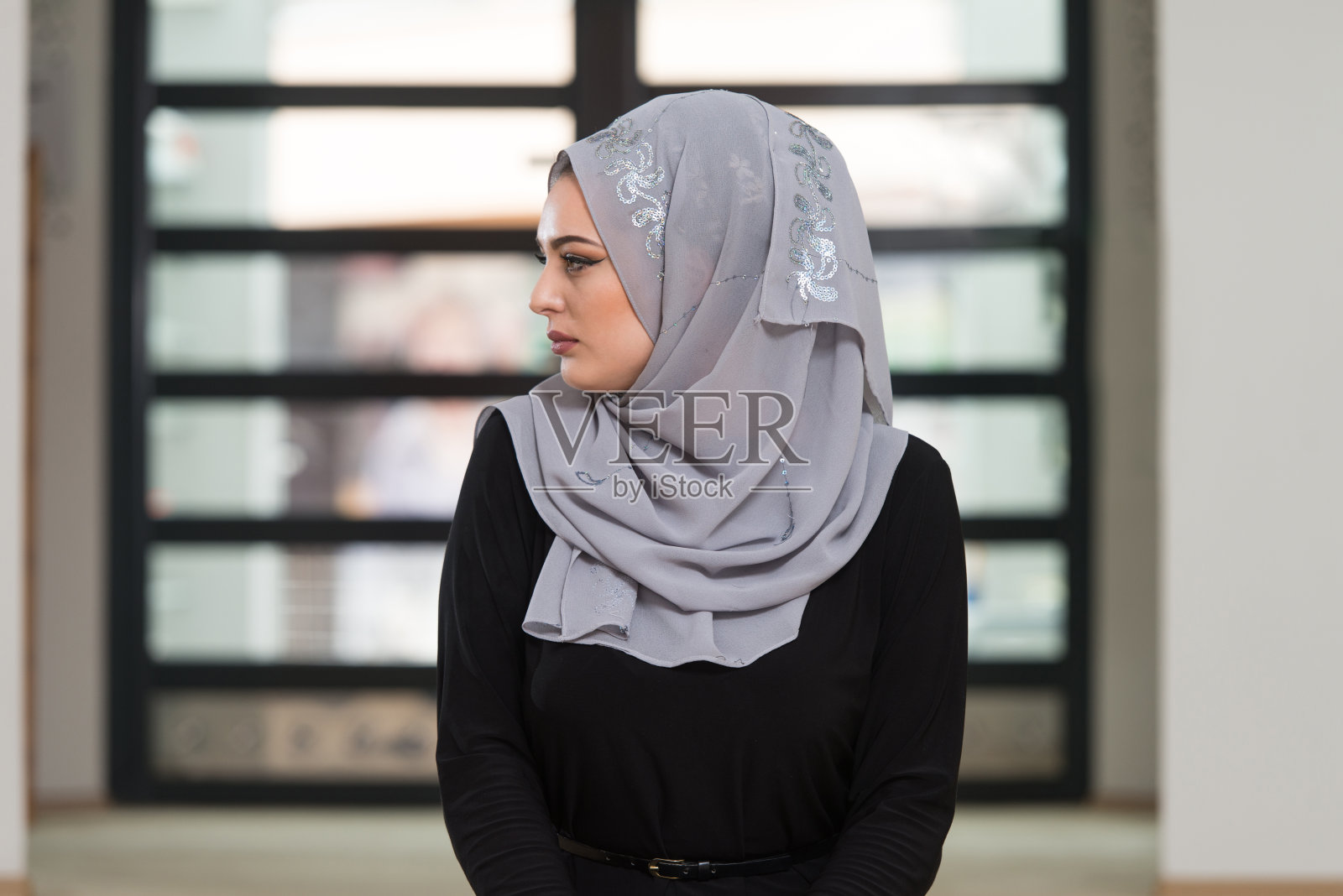 戴着头饰祈祷的年轻白人妇女照片摄影图片