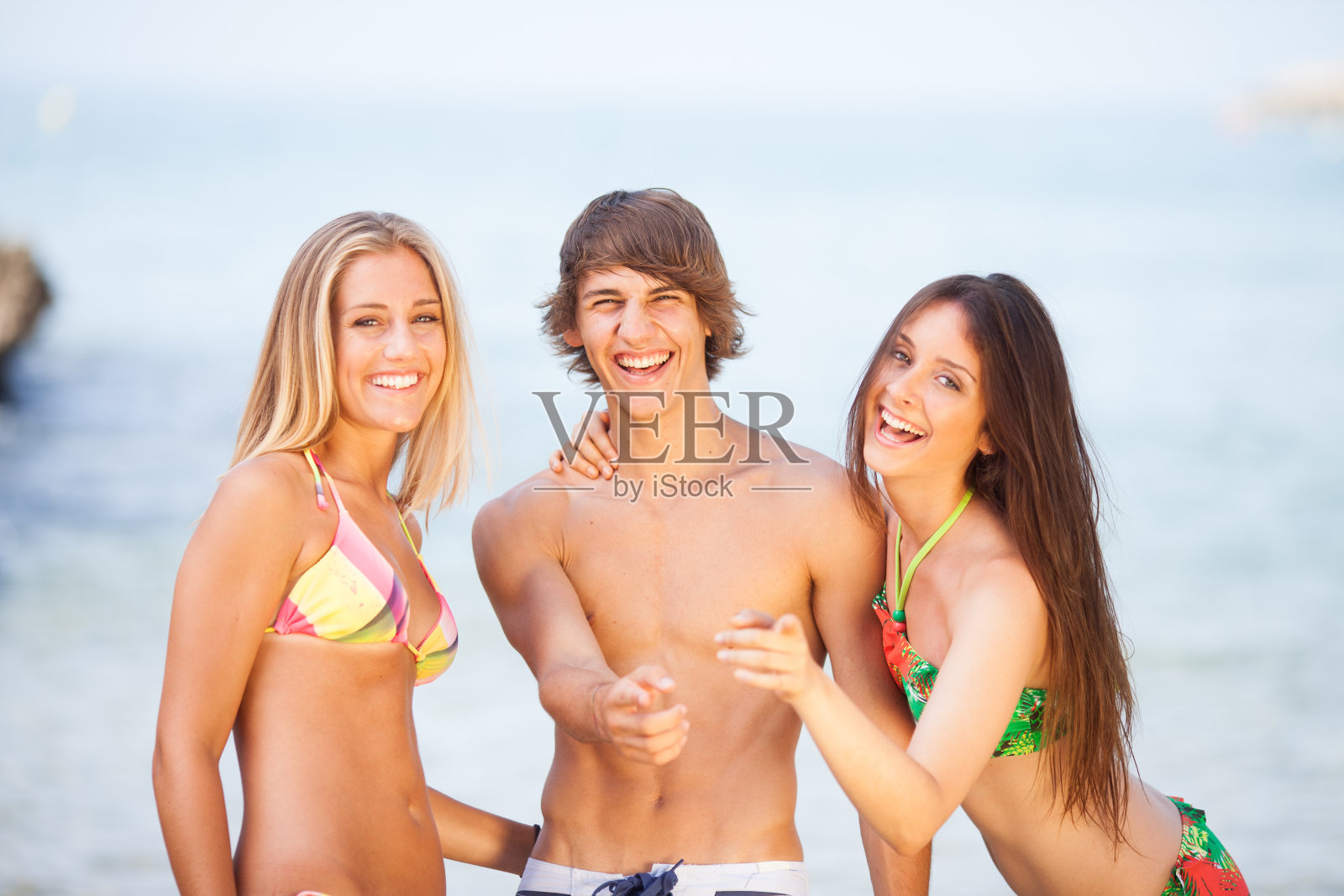 三个年轻漂亮的朋友在海滩上玩照片摄影图片