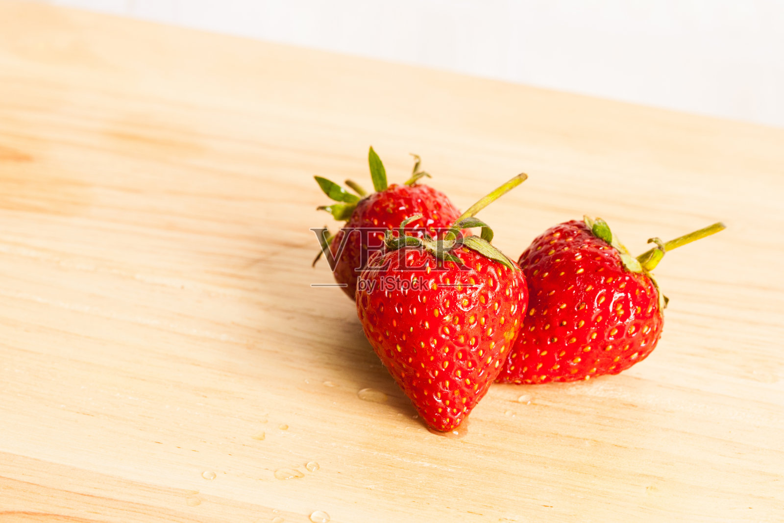 新鲜的草莓放在木头上。照片摄影图片