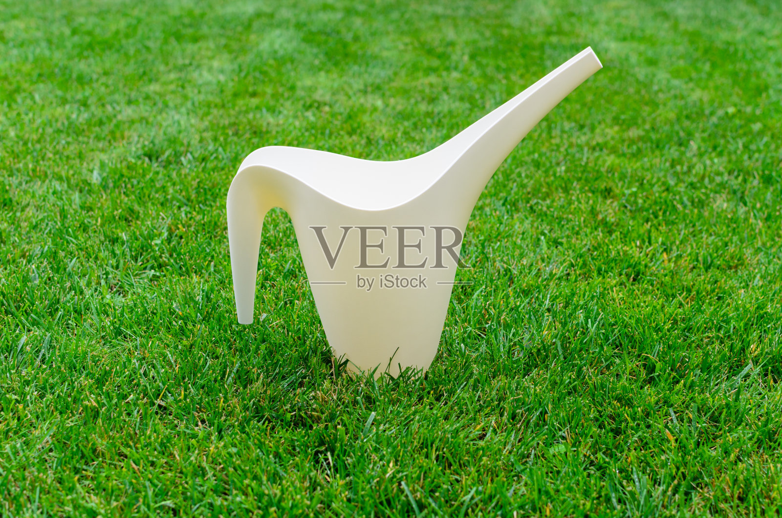 洒水壶放在绿草地上照片摄影图片