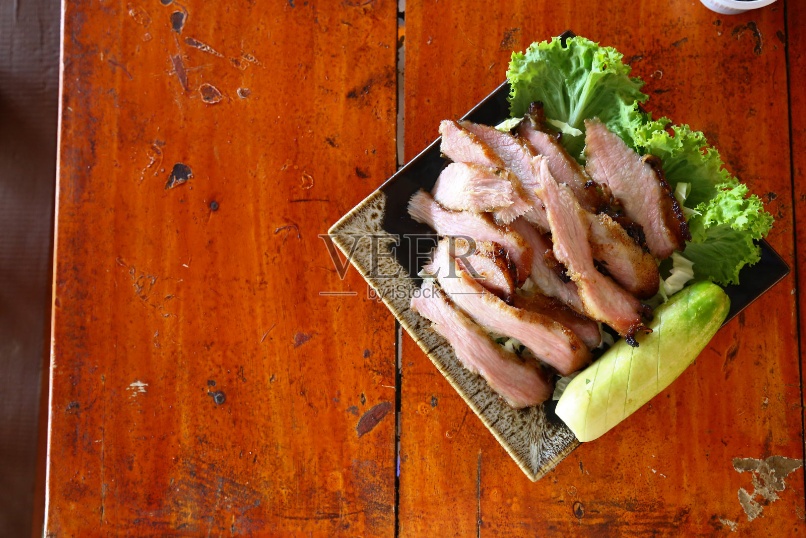 把烤猪肉切片放在盘子里照片摄影图片