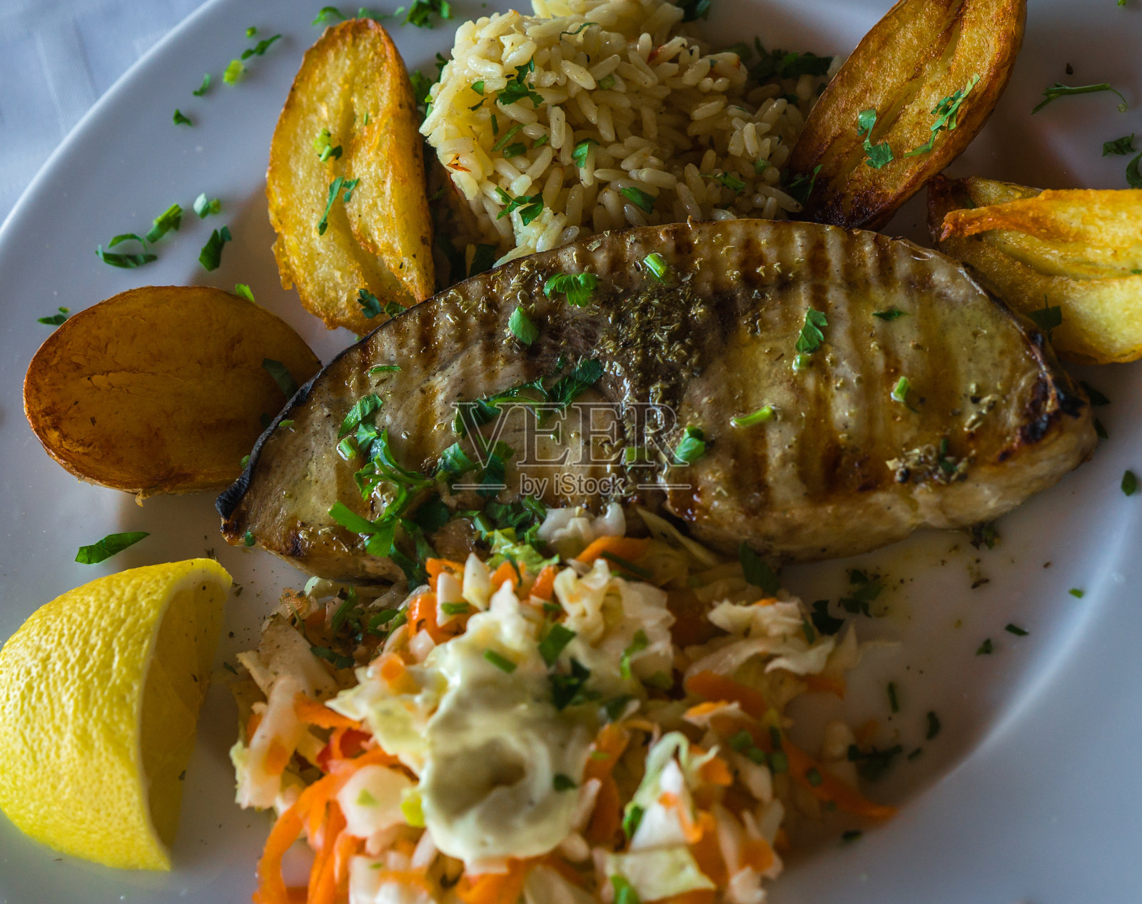 鱼配炸土豆，米饭和沙拉照片摄影图片