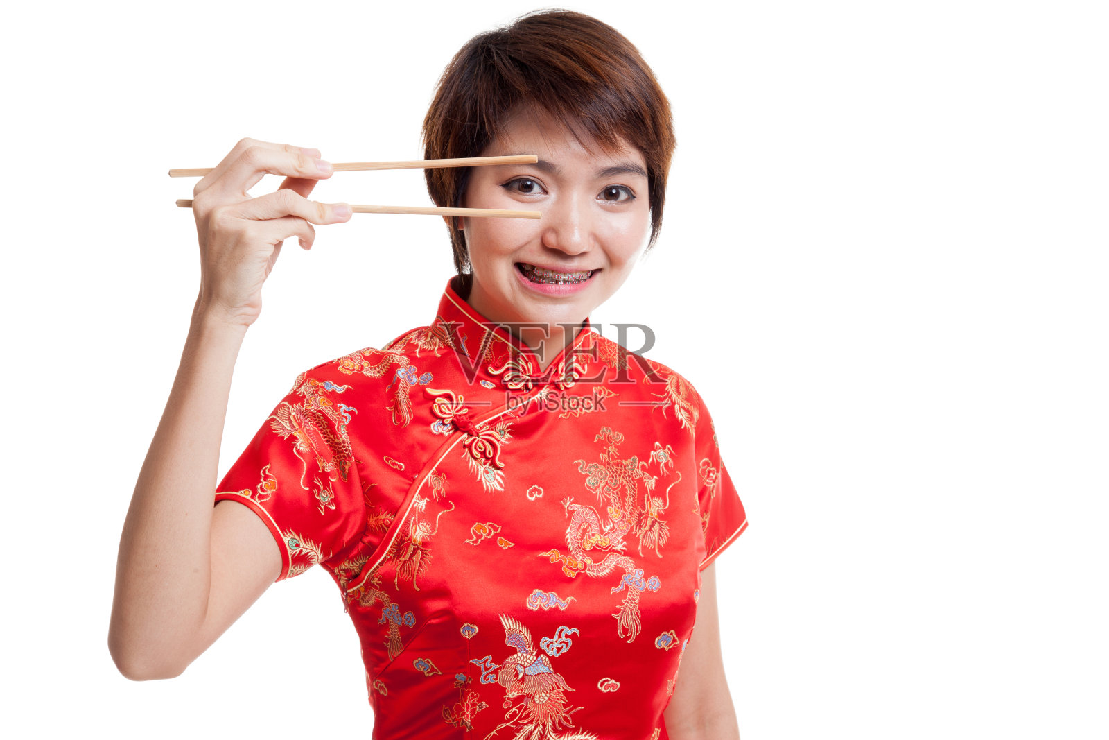 亚洲女孩穿着中国旗袍和筷子。照片摄影图片