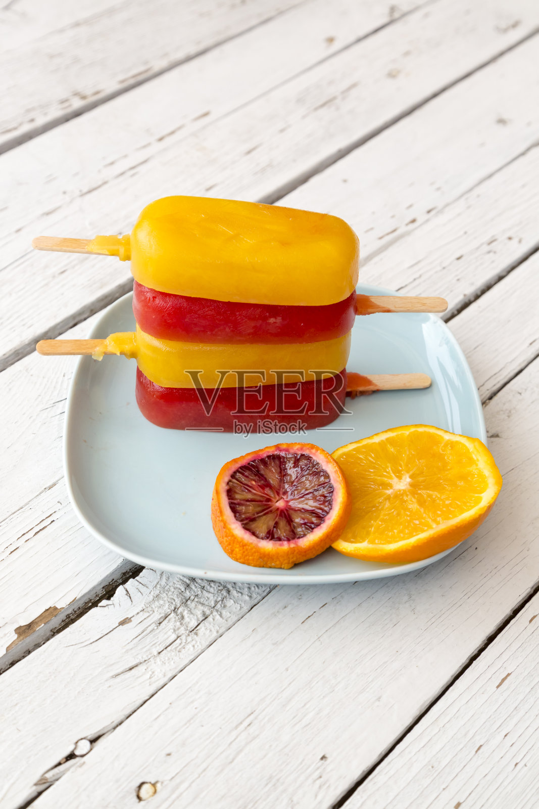 血橙和橙冰淇淋，冰棒在盘子里照片摄影图片