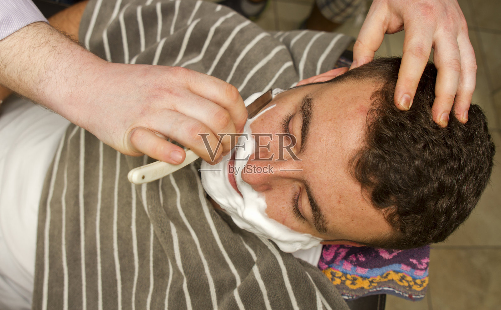 在理发店用直剃刀刮脸照片摄影图片