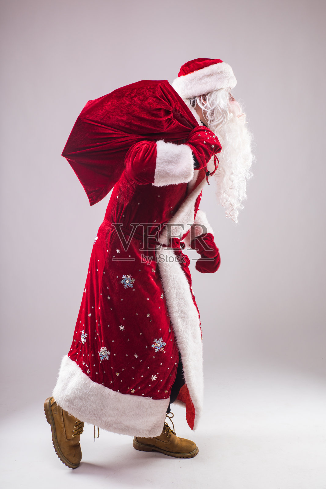 快乐的圣诞老人拿着礼物袋和移动照片摄影图片