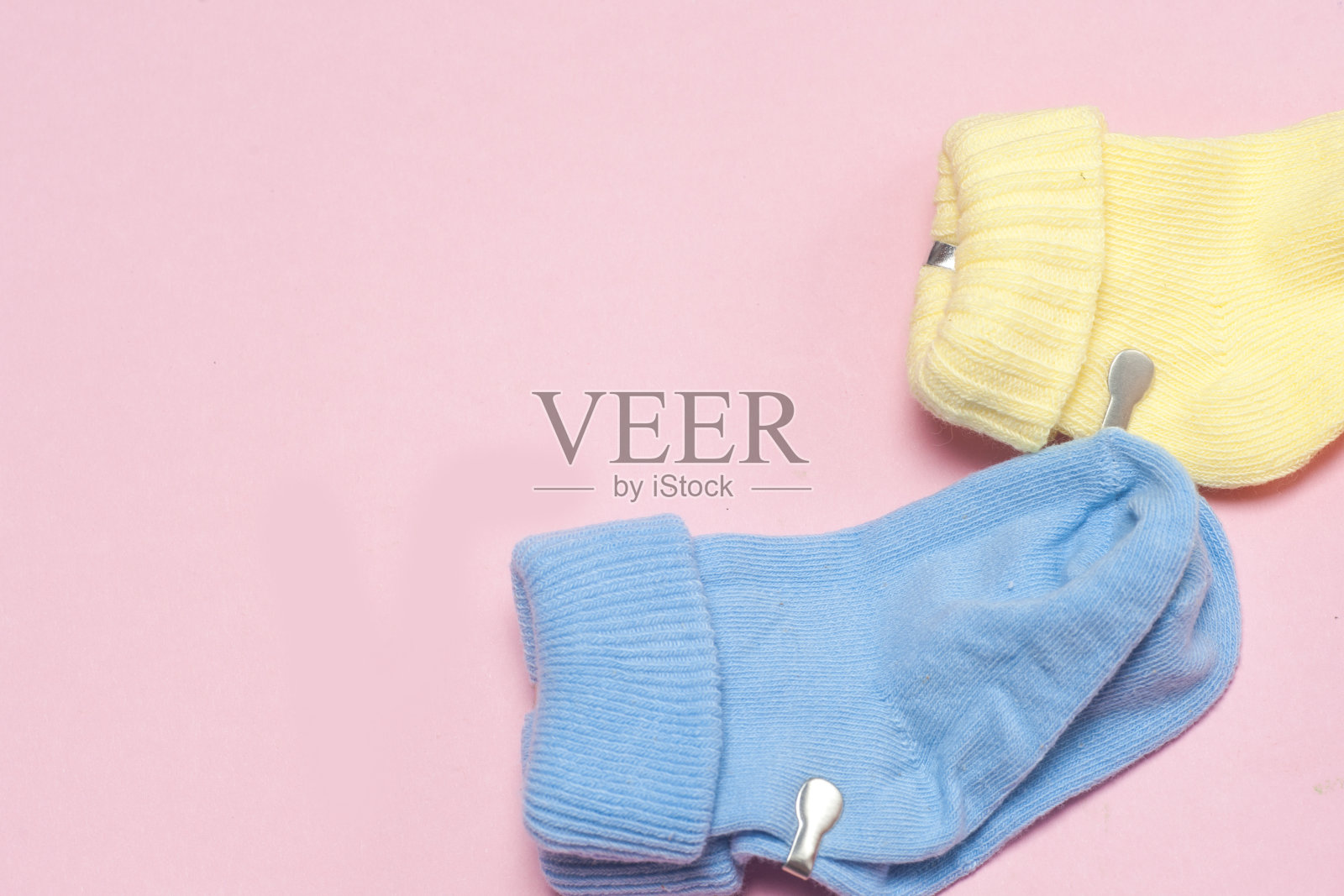 彩色粉色背景的婴儿棉袜。照片摄影图片