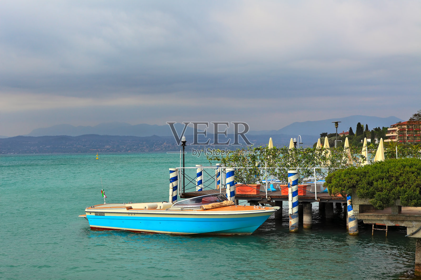 一艘船停泊在意大利Sirmione的加尔达湖上。照片摄影图片