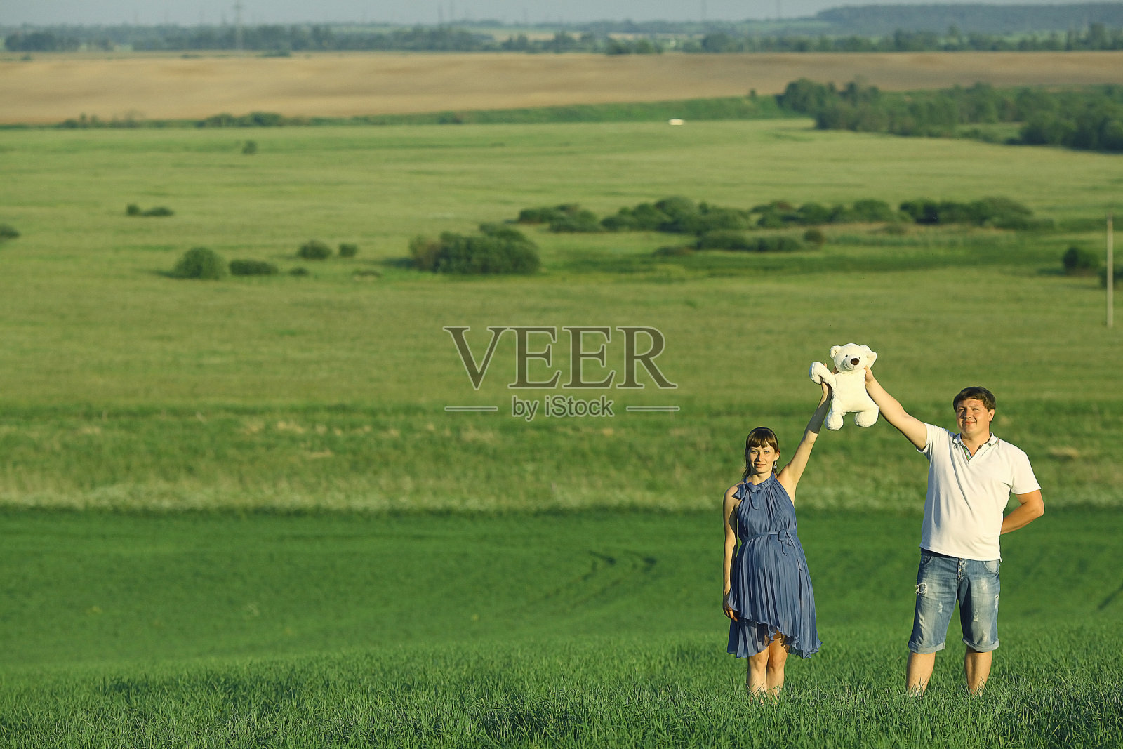 一个男人和一个孕妇在夏天的田野里照片摄影图片